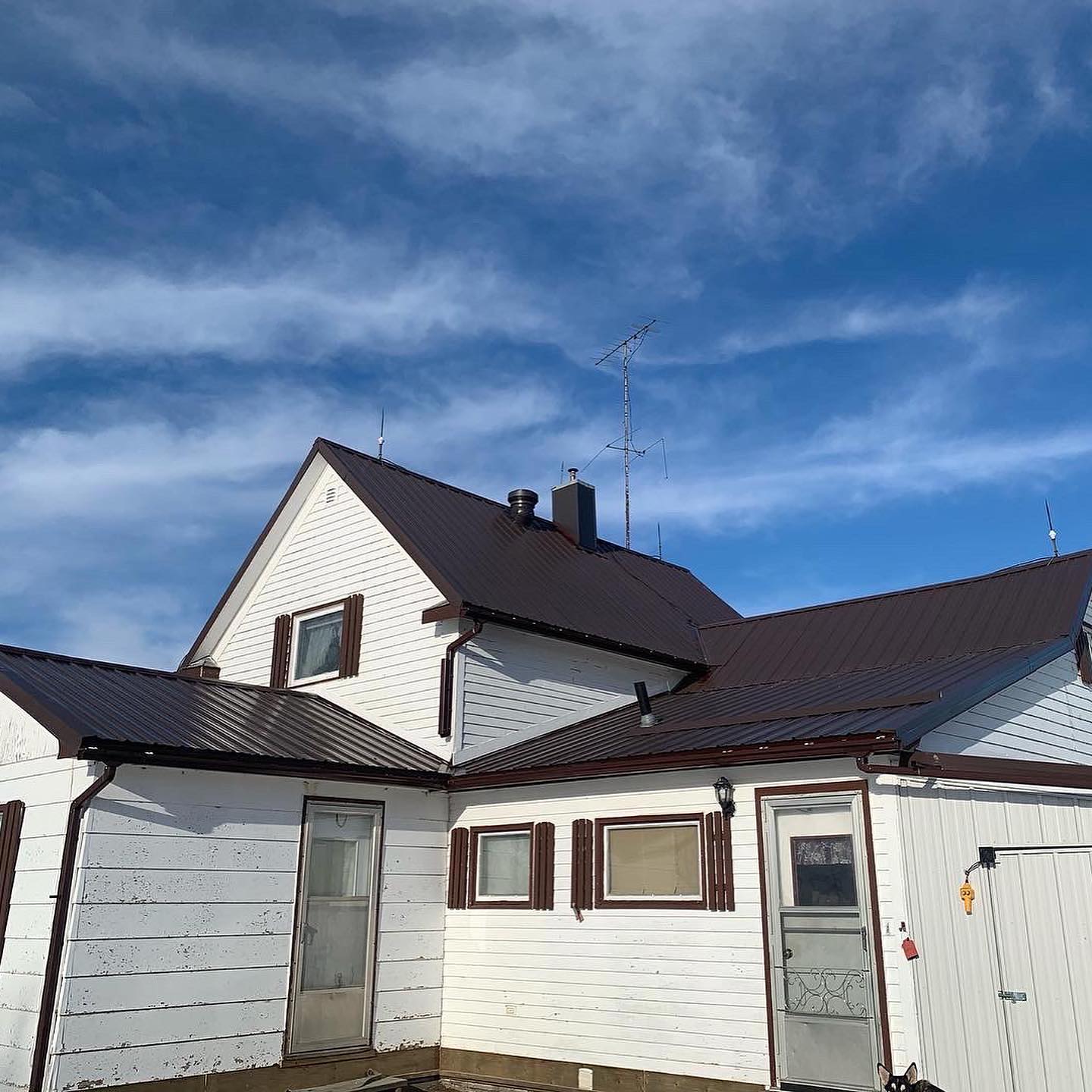 Brown standing seam metal roof installed on a Saskatchewan farm home
